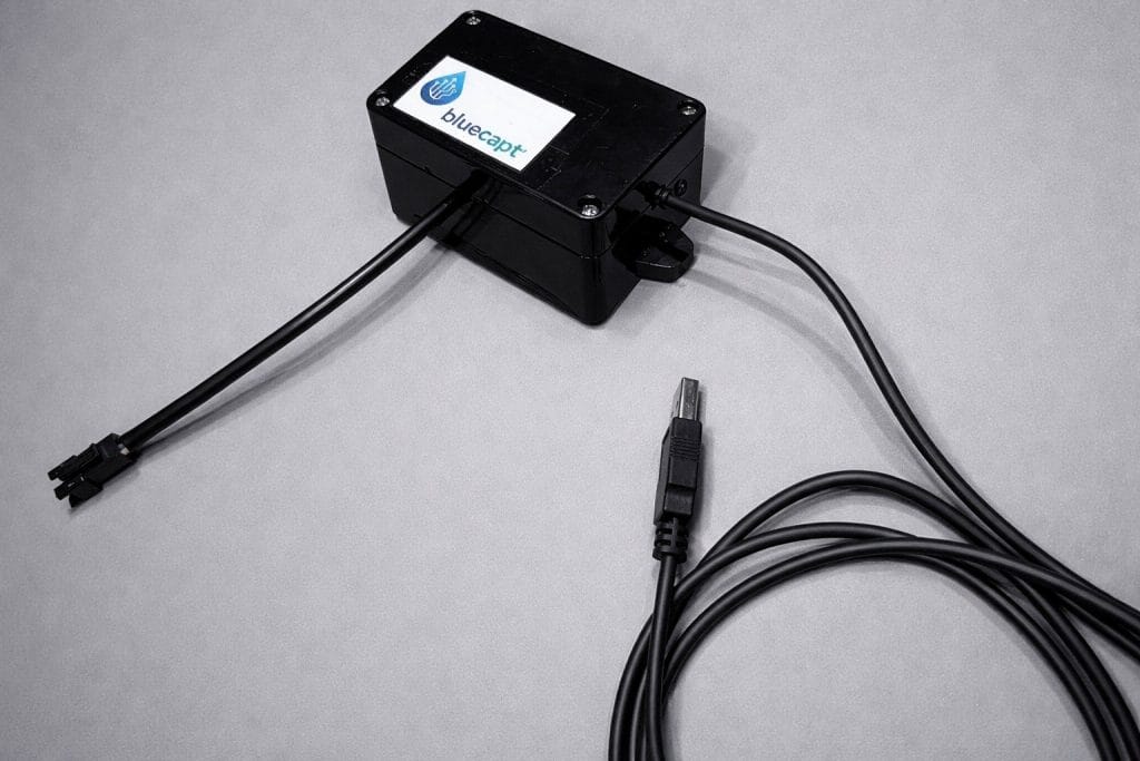 Le boitier bluecapt fermé avec son câble usb et câble pour capteur d'eau